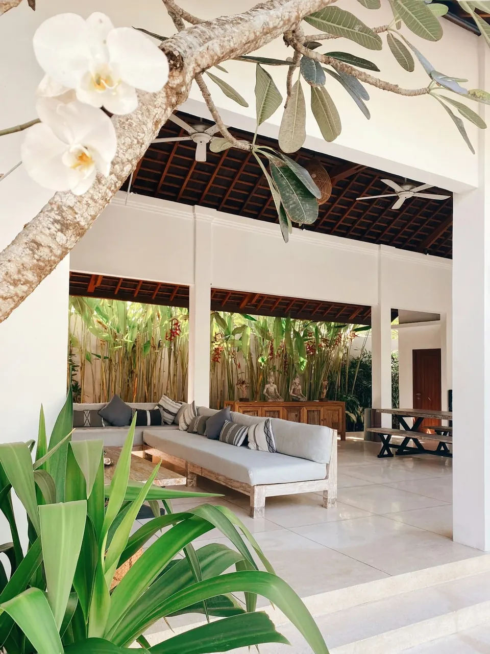 Lounge aperta di una villa in Costiera Amalfitana con piante e sedute chiare